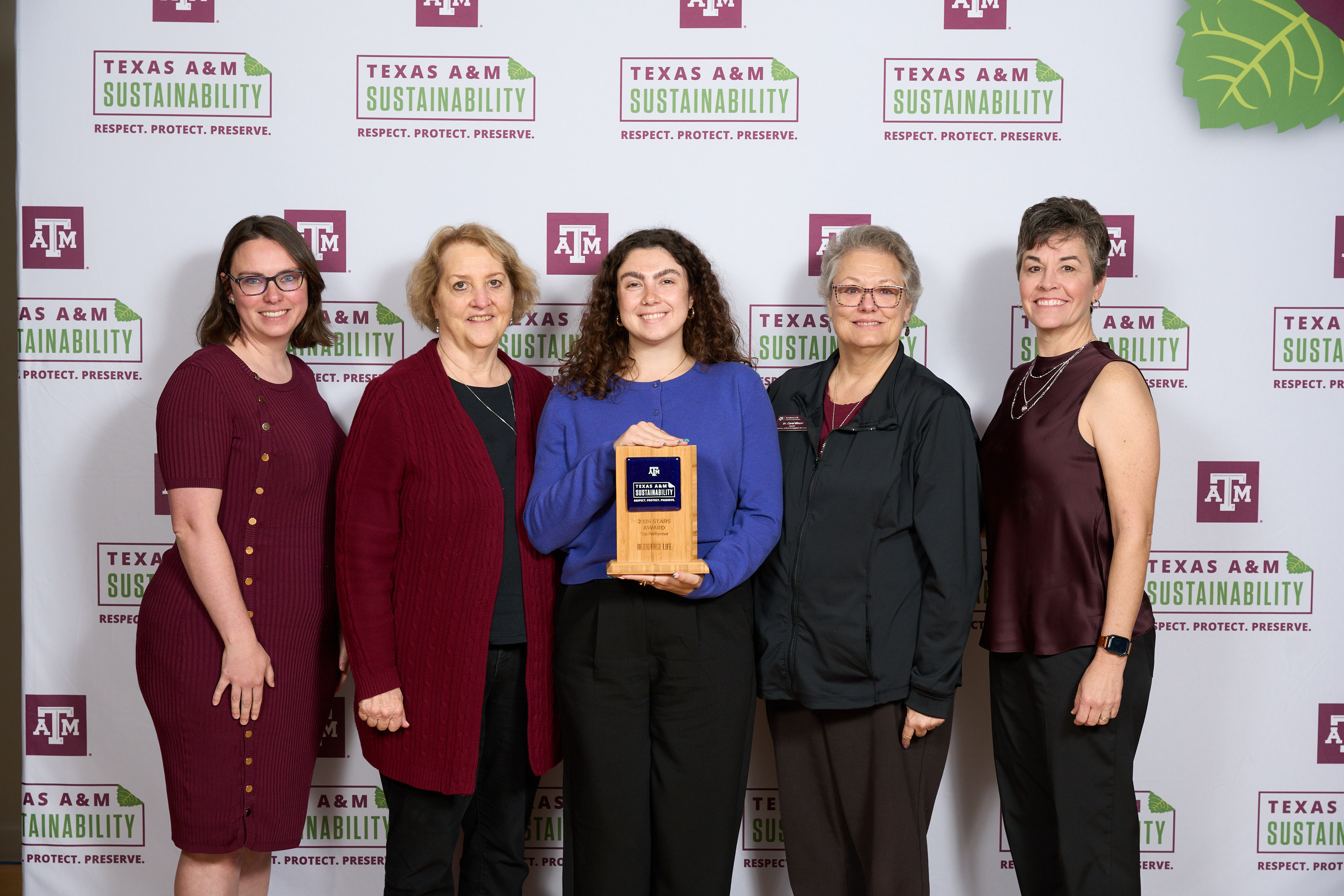 Charney Rydl, Dr. Carol Binzer and Kenya Reeves accepting an award from Kelly Wellman and Danielle Laperriere.